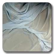 Light blue polyester chiffon fabric draped elegantly, showcasing its soft, lightweight, and crease-resistant qualities.
