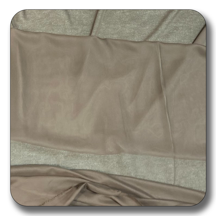 Soft beige polyester chiffon fabric, lightweight and crease-resistant, sold by the yard for various crafting projects.