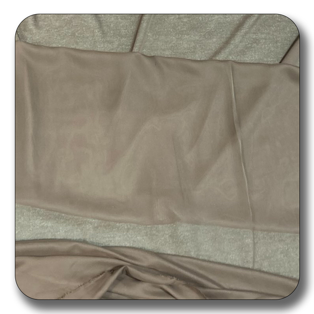 Soft beige polyester chiffon fabric, lightweight and crease-resistant, sold by the yard for various crafting projects.