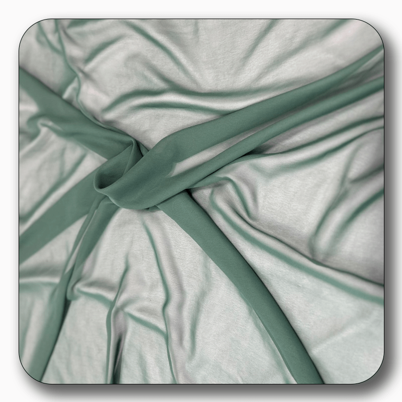 Close-up of soft polyester chiffon fabric in light green, showcasing its smooth texture and elegant drape.