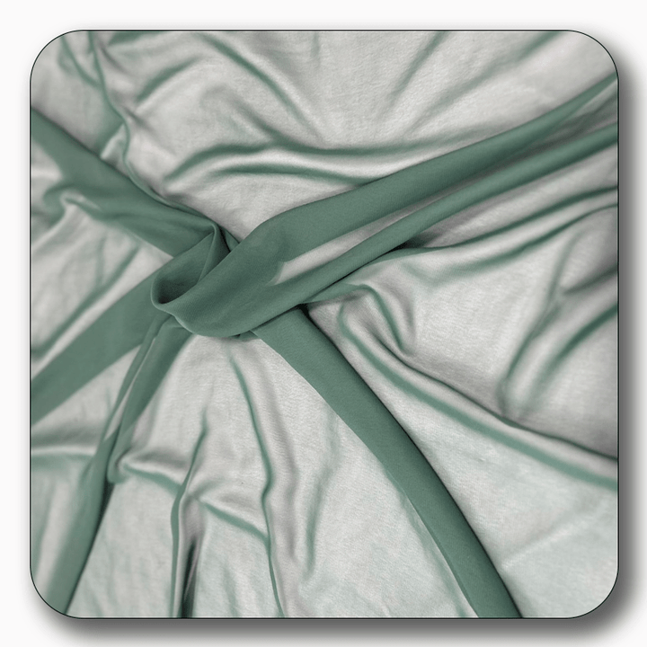 Close-up of soft polyester chiffon fabric in light green, showcasing its smooth texture and elegant drape.