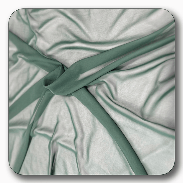 Close-up of soft polyester chiffon fabric in light green, showcasing its smooth texture and elegant drape.