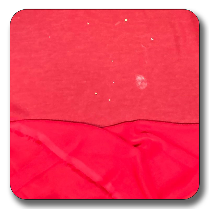 Close-up of red chiffon fabric showing texture and slight imperfections, suitable for various sewing projects.