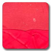 Close-up of red chiffon fabric showing texture and slight imperfections, suitable for various sewing projects.