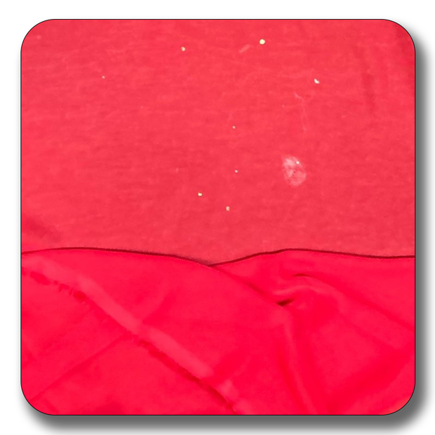 Close-up of red chiffon fabric showing texture and slight imperfections, suitable for various sewing projects.